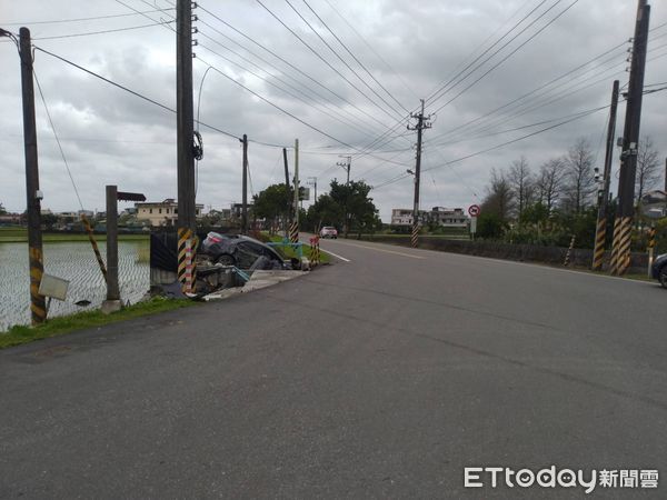 ▲▼轎車疑過彎失控，撞電線桿後栽進農水路閘門內，釀2輕傷。（圖／記者游芳男翻攝，下同）