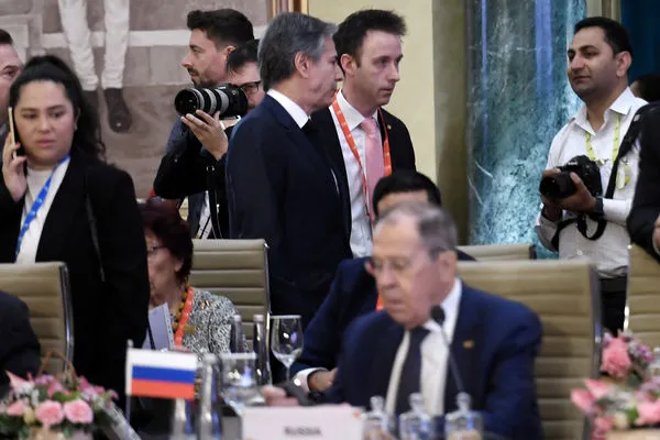 ▲▼布林肯（後）在G20外交部長會議場邊，拉夫羅夫（Sergei Lavrov）坐在位子上。（圖／路透）