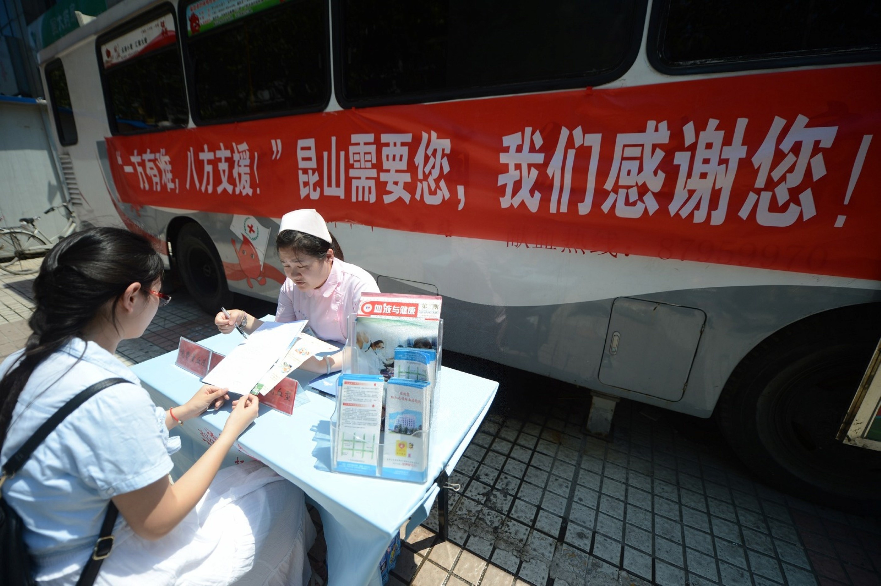 8月3日，在江蘇揚州時代廣場，一市民來到獻血車前諮詢情況。（圖／新華社提供）