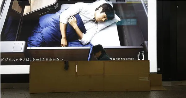 日本夜逃屋服務，專門「消失」客戶。圖為新宿站一名街友坐在紙箱中。（示意圖／達志／美聯社）
