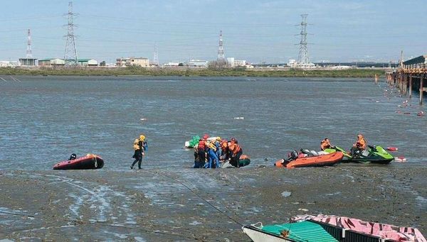 海巡人員在海岸邊打撈偷渡客浮屍。（海巡署提供）