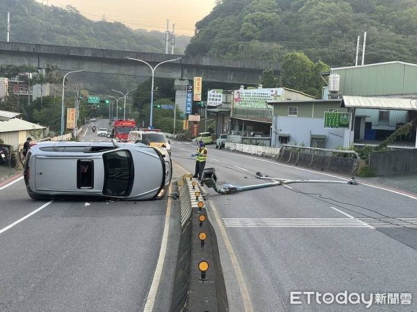 ▲▼車輛側翻橫躺路中，遭撞的路燈桿傾倒對向車。（圖／龜山警分局提供）