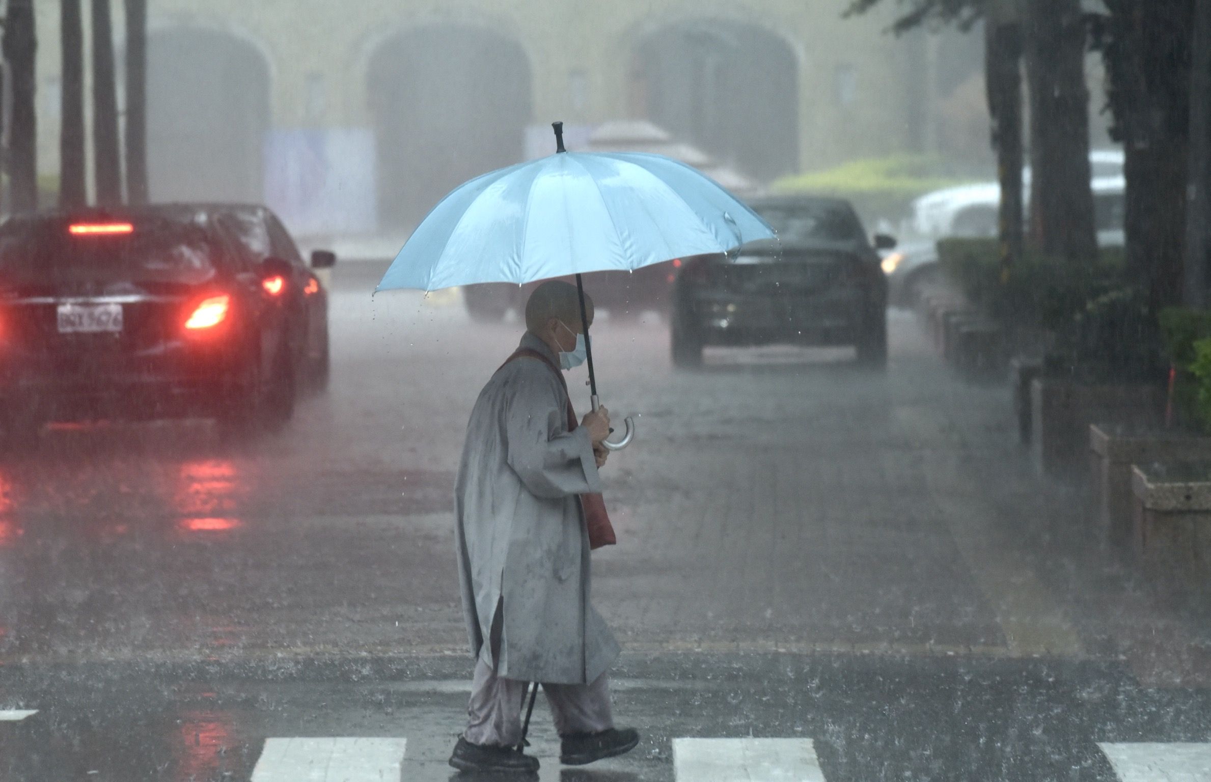 ▲▼天氣,行人路權,路人,雷雨,口罩,斑馬線,過馬路,大雨,大雷雨,下雨,雨天,豪大雨,午後雷陣雨,梅雨,降雨,氣象,豪雨,颱風外圍環流,西南氣流,滯留鋒面,撐傘,雨傘,陰雨綿綿,潮濕,濕度,熱對流,天氣配圖。（圖／記者李毓康攝）