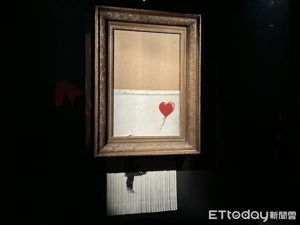 ▲▼身份成謎的神秘藝術家班克斯(Banksy)創作當代藝術史上最轟動的「自毀作品」《垃圾桶中的愛》(Love is in the Bin)如今來台展出。（圖／記者林育綾攝）