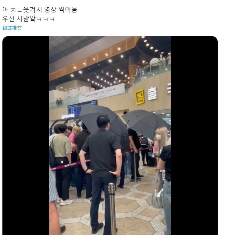 &TEAM工作人員在機場內打傘，只為了擋住粉絲拍照。（圖／翻攝自推特）