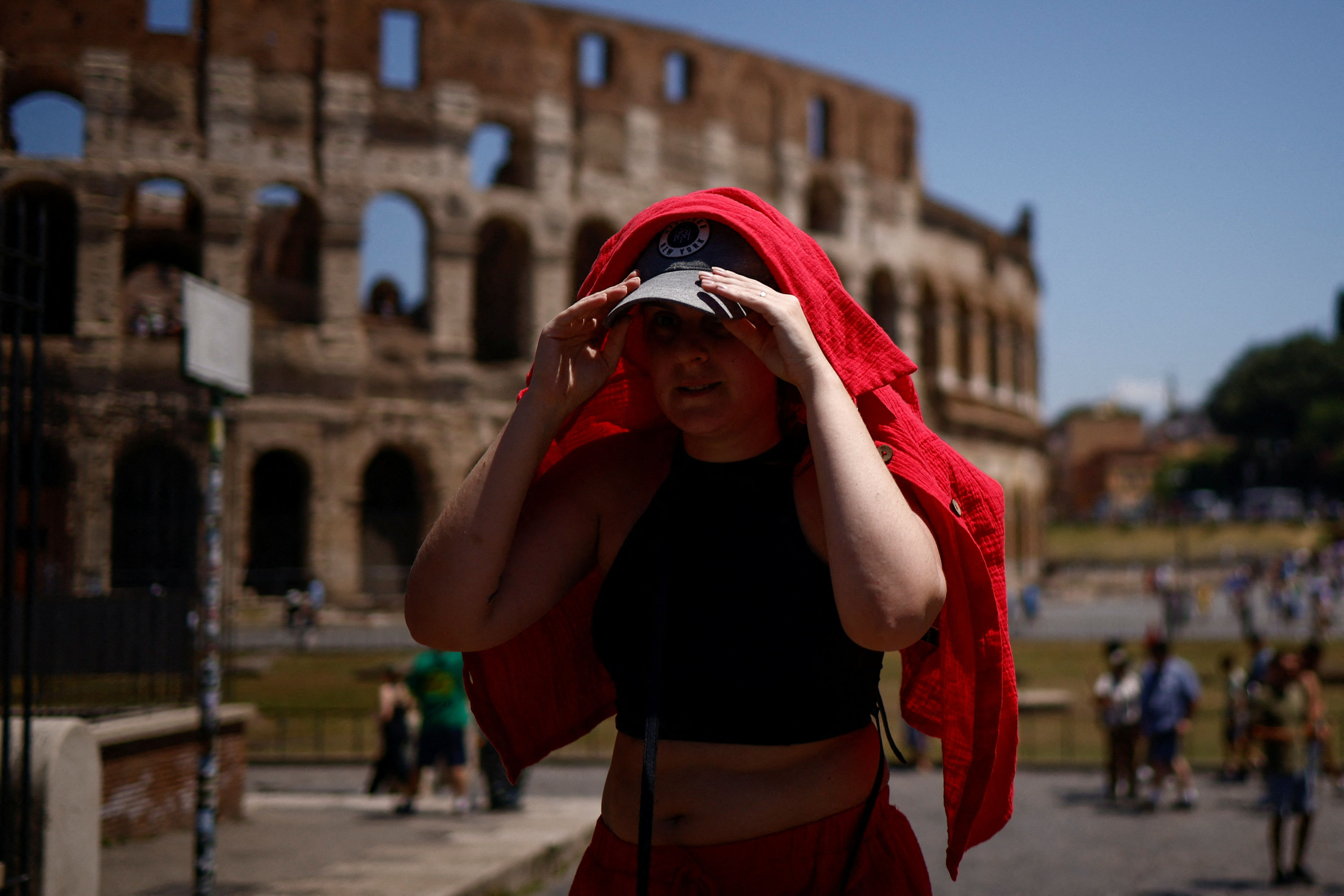 ▲▼義大利羅馬高溫逼近40度，一名女性用衣物遮蔽陽光。（圖／路透）