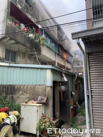 ▲台南市善化區民生路1棟3樓鐵皮加蓋民宅發生火警，3樓處有濃煙、明火竄出，消防人員接駁水線延伸進火場全力射水搶救。（圖／記者林悅翻攝，下同）