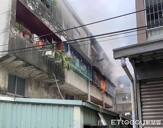 ▲台南市善化區民生路1棟3樓鐵皮加蓋民宅發生火警，3樓處有濃煙、明火竄出，消防人員接駁水線延伸進火場全力射水搶救。（圖／記者林悅翻攝，下同）