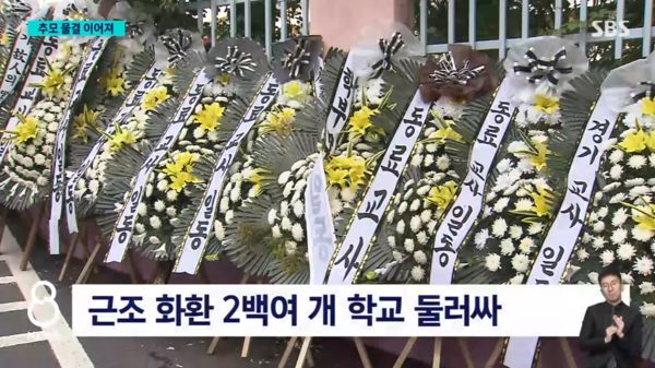 ▲23歲女老師輕生離世，全南韓教師送花環到首爾瑞二小學表達哀悼之意。（圖／翻攝自YouTube／SBS 뉴스）