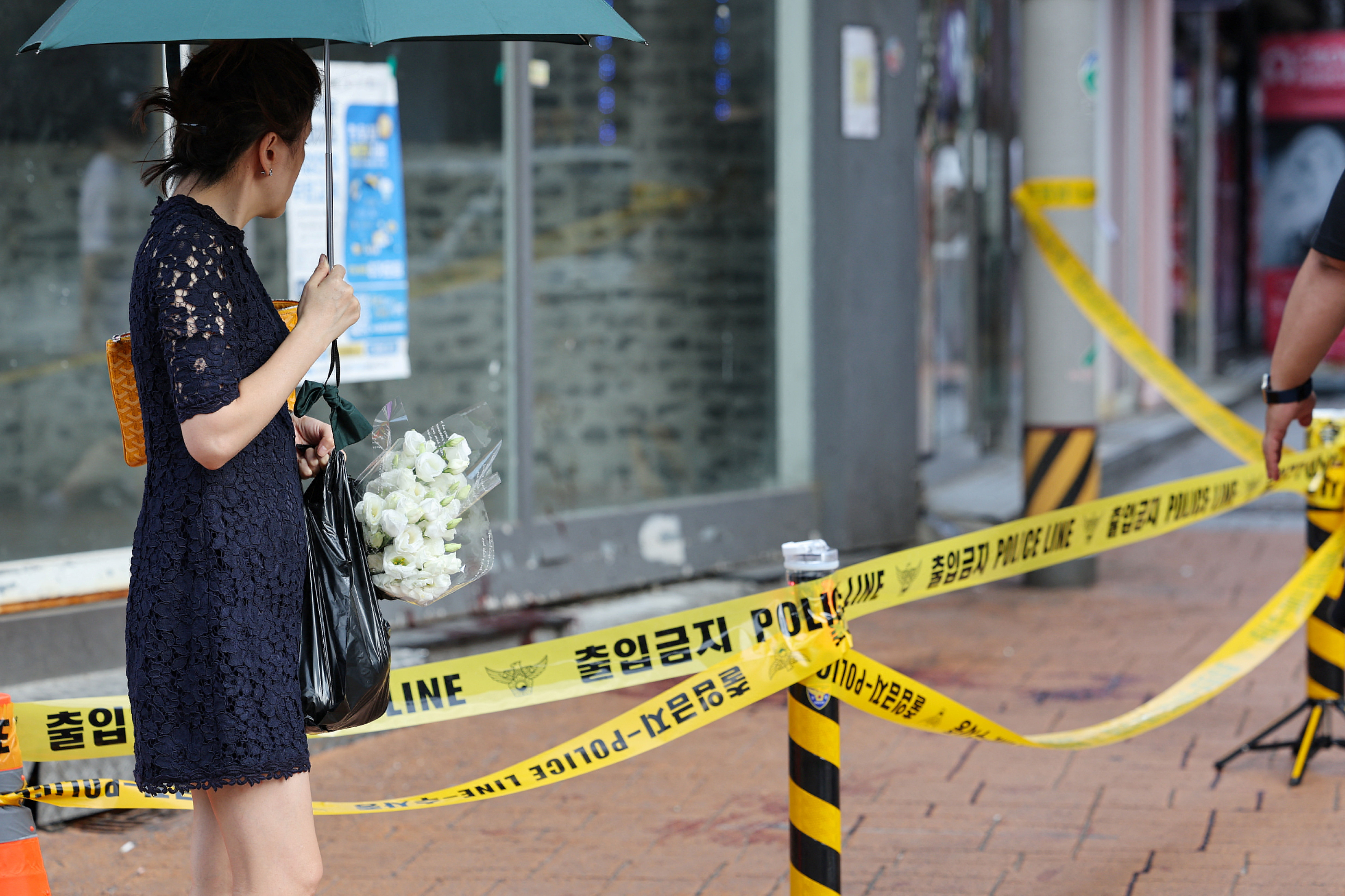 ▲▼一名20多歲年輕男性在首爾地鐵新林洞站4號出口附近遭遇隨機殺人死亡，民眾22日在現場持白菊哀悼。（圖／路透）