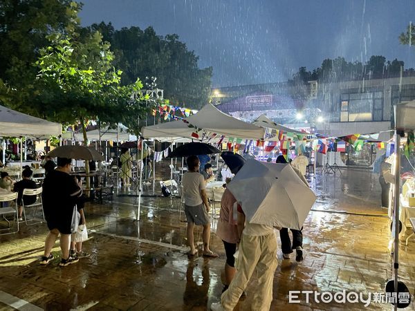 ▲參與活動的民眾頂著大雨欣賞舞台上的演出。（圖／記者趙禕攝）