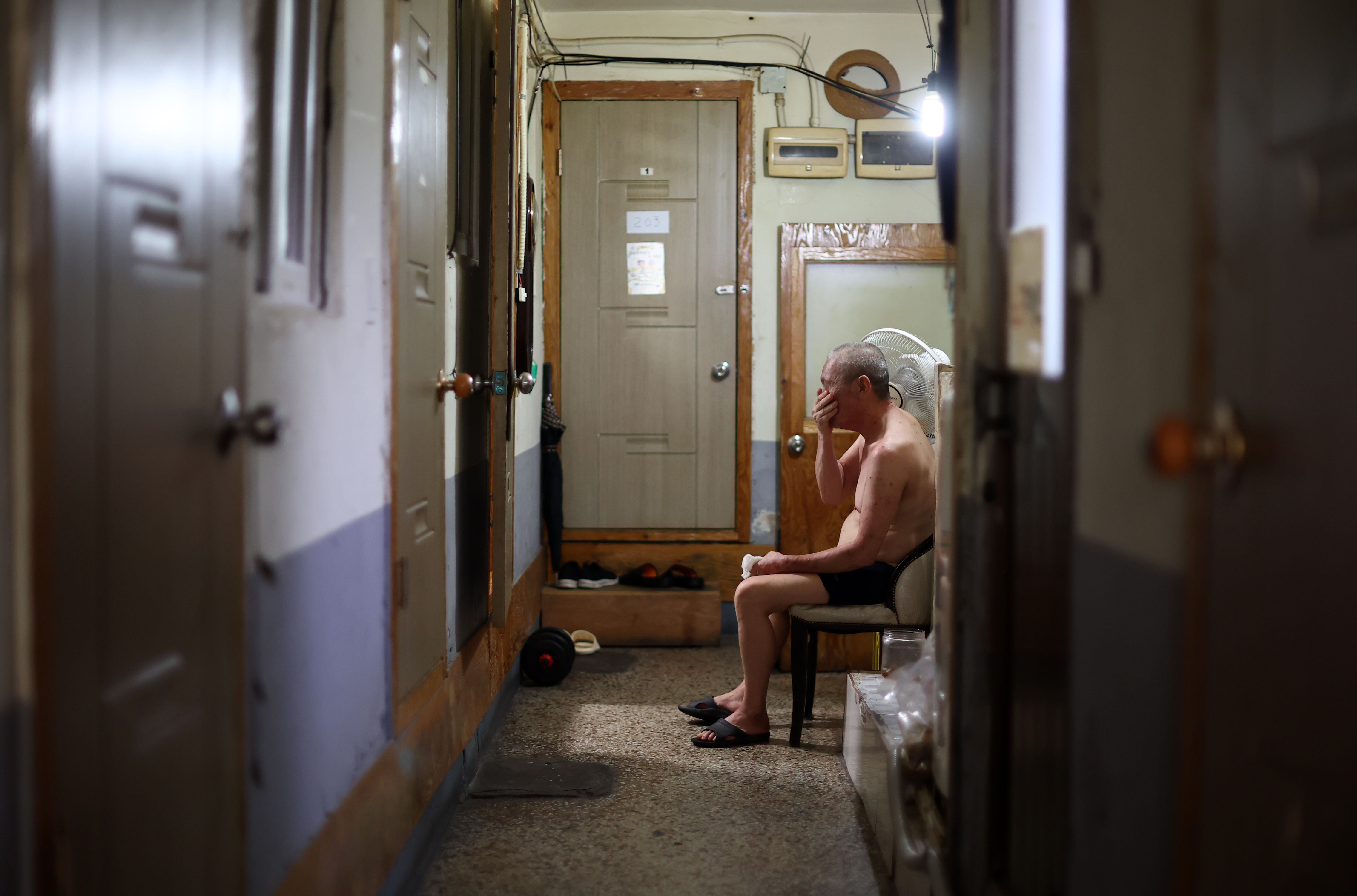 ▲▼南韓首爾一名赤裸上身的老年男性，1日坐在廉價旅館內的電風扇旁，預估氣溫高達35度。（圖／達志影像／newscom）