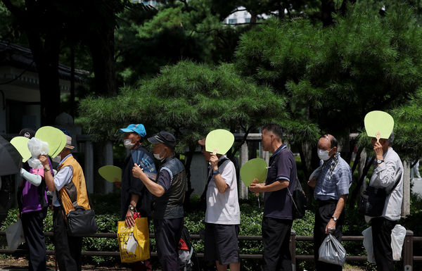 ▲▼南韓首爾的老人頂著高溫排隊領取免費便當。（圖／達志影像／newscom）