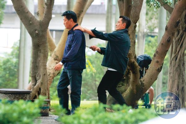 15：58，柯叔元（右）拿了樹枝從背後頂著庹宗華（左），像是在威脅他，兩人正拍攝衛視新戲。