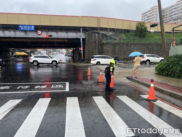 ▲台南降下豪雨，市區多處積水，警方冒大雨派員拉起封鎖線管理交通，維護人車安全。（圖／記者林東良翻攝，下同）