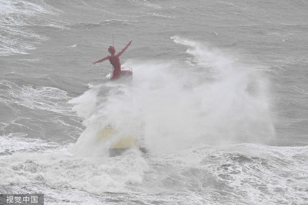 ▲▼卡努颱風襲南韓，釜山海邊出現大浪，民眾穿雨衣抵抗風雨。（圖／CFP）