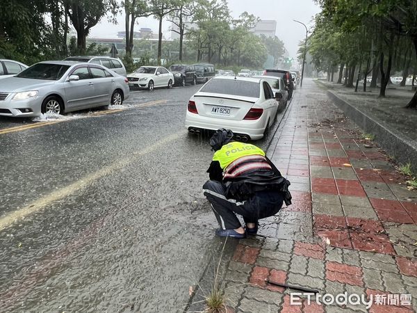 ▲台南市警六分局金華所巡佐劉文祥，冒雨執勤時，發現路旁排水孔疑遭阻塞，也冒雨主動清除淤塞物，促進排水，此景被民眾看到，都深受感動，認為警察十分盡心盡職。（圖／記者林東良翻攝，下同）