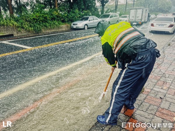 ▲台南市警六分局金華所巡佐劉文祥，冒雨執勤時，發現路旁排水孔疑遭阻塞，也冒雨主動清除淤塞物，促進排水，此景被民眾看到，都深受感動，認為警察十分盡心盡職。（圖／記者林東良翻攝，下同）