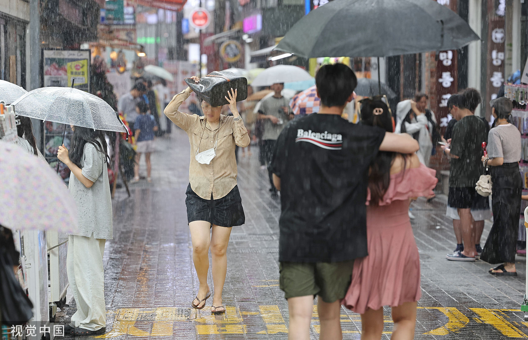 ▲▼今年7月底，南韓首爾明洞街頭行人正在躲避降雨。（圖／CFP）