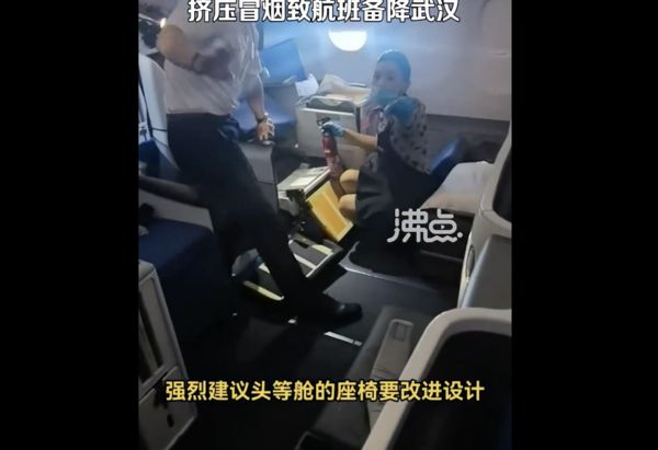 ▲東航乘客行動電源卡座椅深處冒煙，空服員急拆座椅查看。（圖／翻攝沸點視頻）