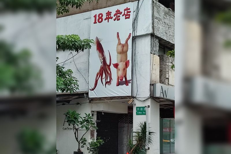 ▲▼餐廳的廣告上印有魷魚以及倒立的豬，讓人猜不出究竟是在賣什麼。（圖／翻攝臉書／路上觀察學院）