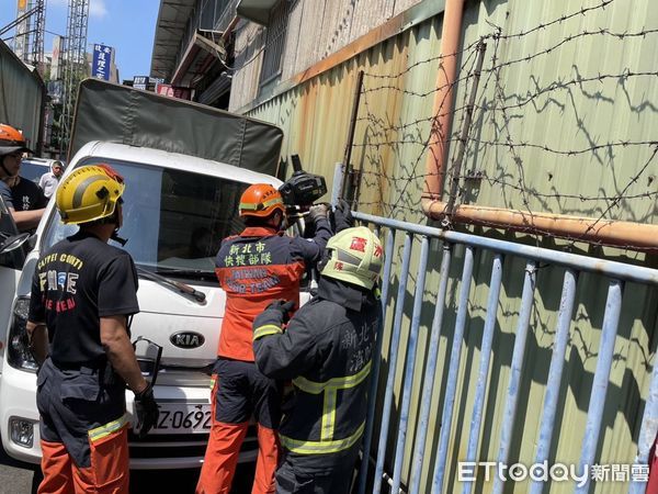 ▲高男修車時不慎遭夾困在車輛與牆壁之間。（圖／記者陳以昇翻攝）