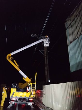 ▲▼高雄風災大停電！工廠鐵皮屋頂卡高壓導線，台電兄弟檔冒風雨搶修。（圖／台電提供）