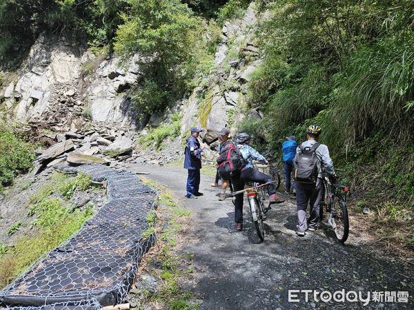 ▲▼警方接獲報案後抵達大鹿林道山壁崩落現場，一邊警戒、一邊協助受困登山客快速將腳踏車抬過落石處。（圖／警方提供）