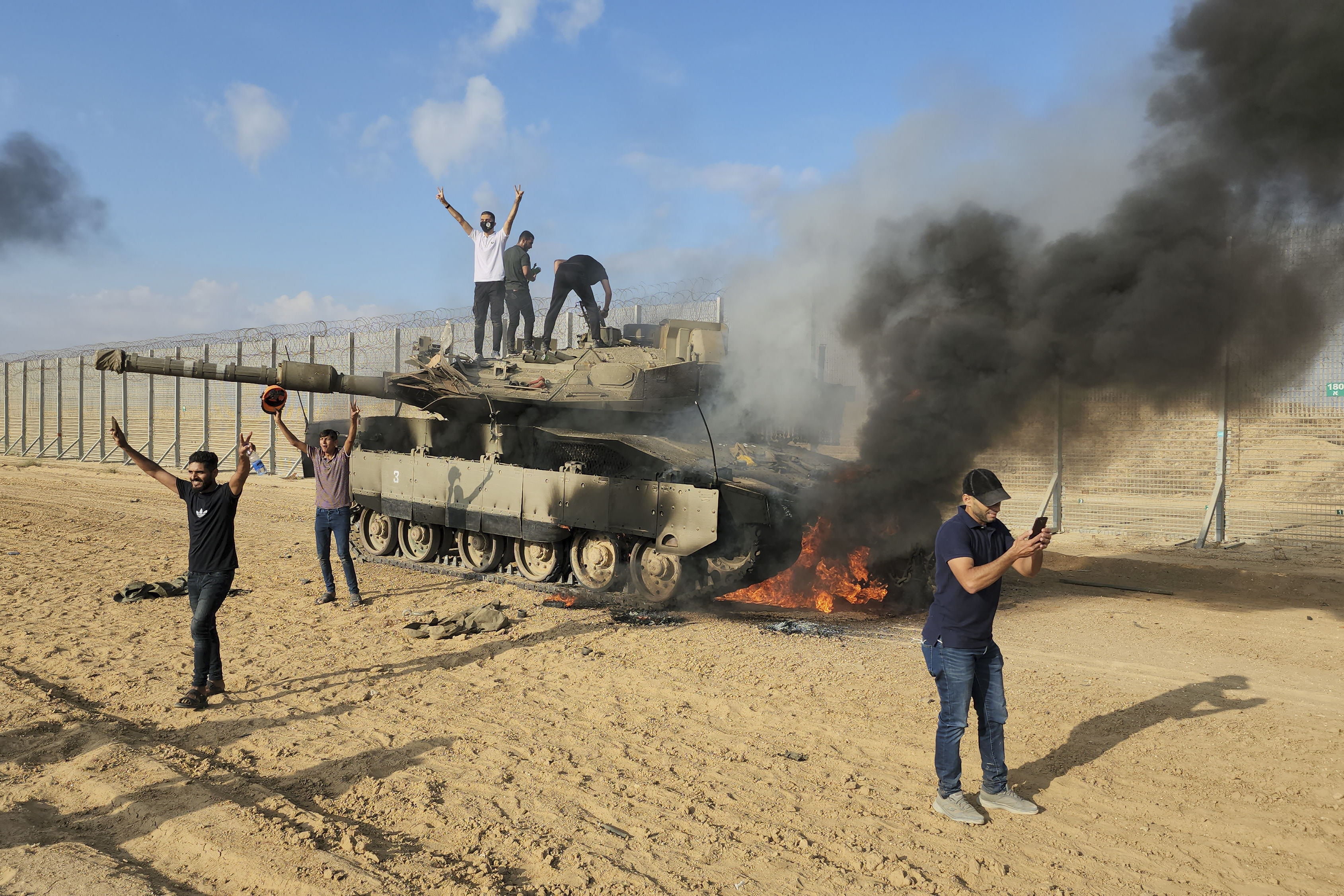 ▲▼巴勒斯坦人在被哈瑪斯摧毀的以色列坦克旁慶祝。（圖／達志影像／美聯社）