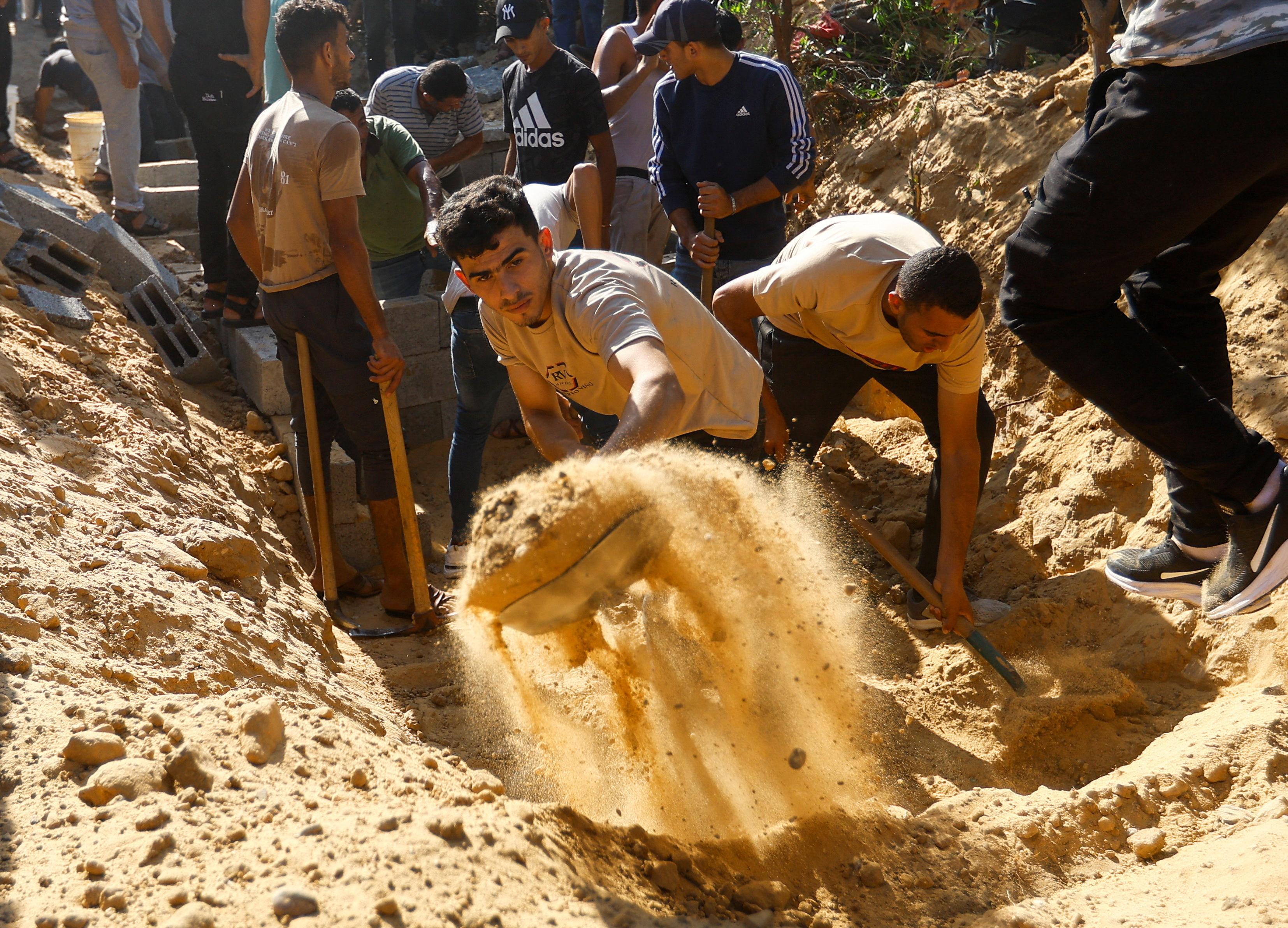 ▲▼加薩走廊南部城市汗尤尼斯（Khan Younis）的巴勒斯坦人正在挖掘墳墓，以舉行葬禮。（圖／路透）