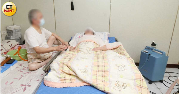 湯奶奶倒臥在醫療床上，一旁簡便的躺臥區就是湯先生的生活起居處所。（圖／趙世勳攝）