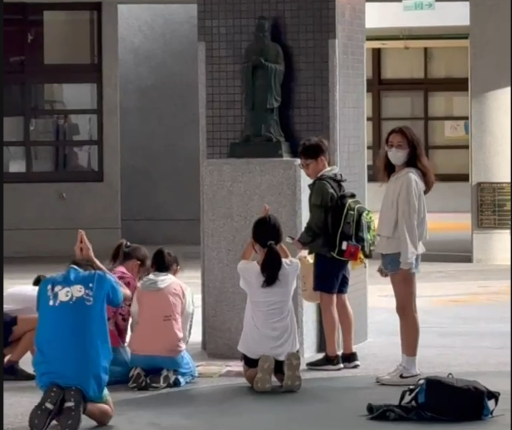 ▲北市延平國小學生在孔子銅像前下跪祈求期中考順利。（圖／校方提供）
