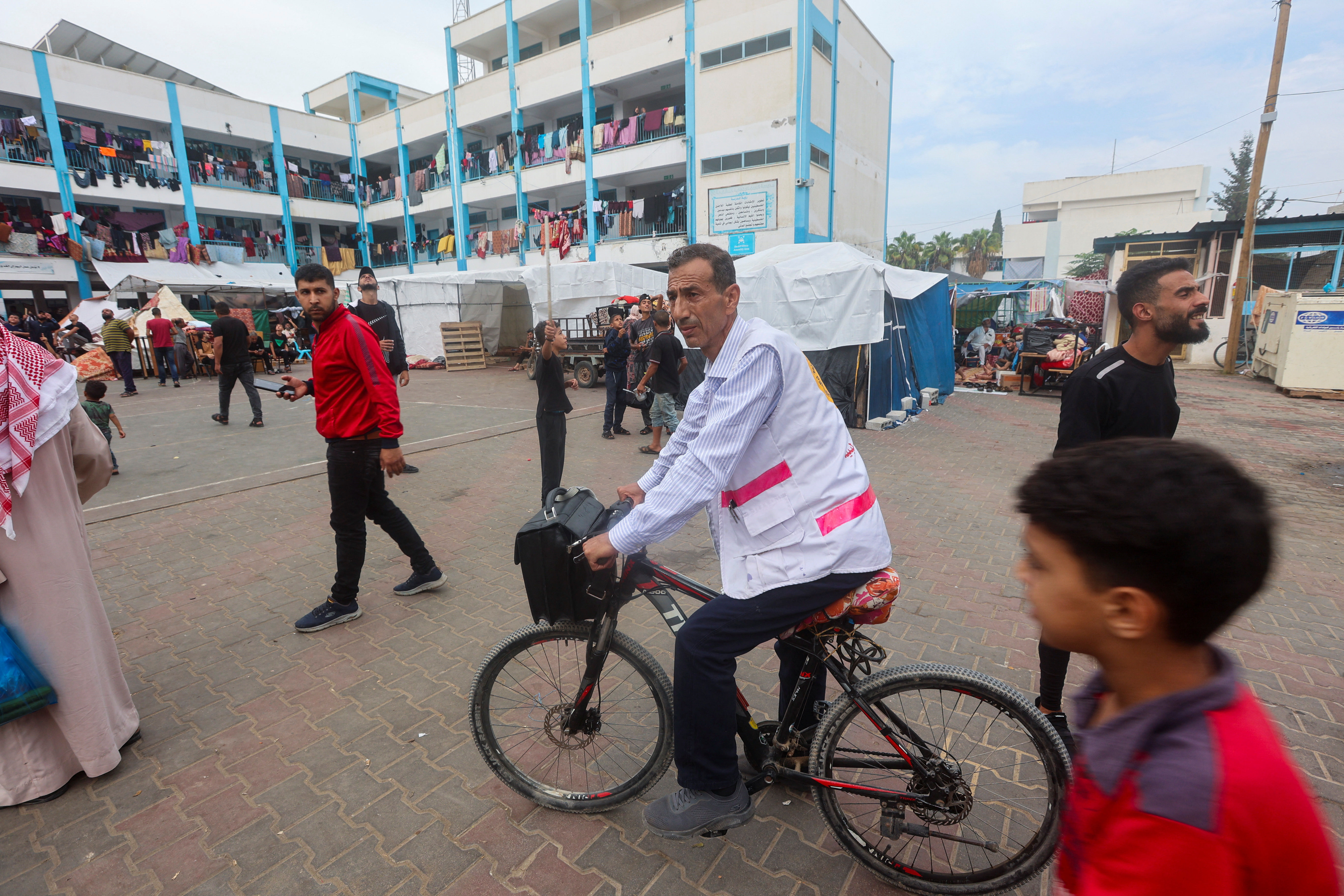 ▲▼ 加薩醫師騎腳踏車來回各個避難所治療患者。（圖／路透）