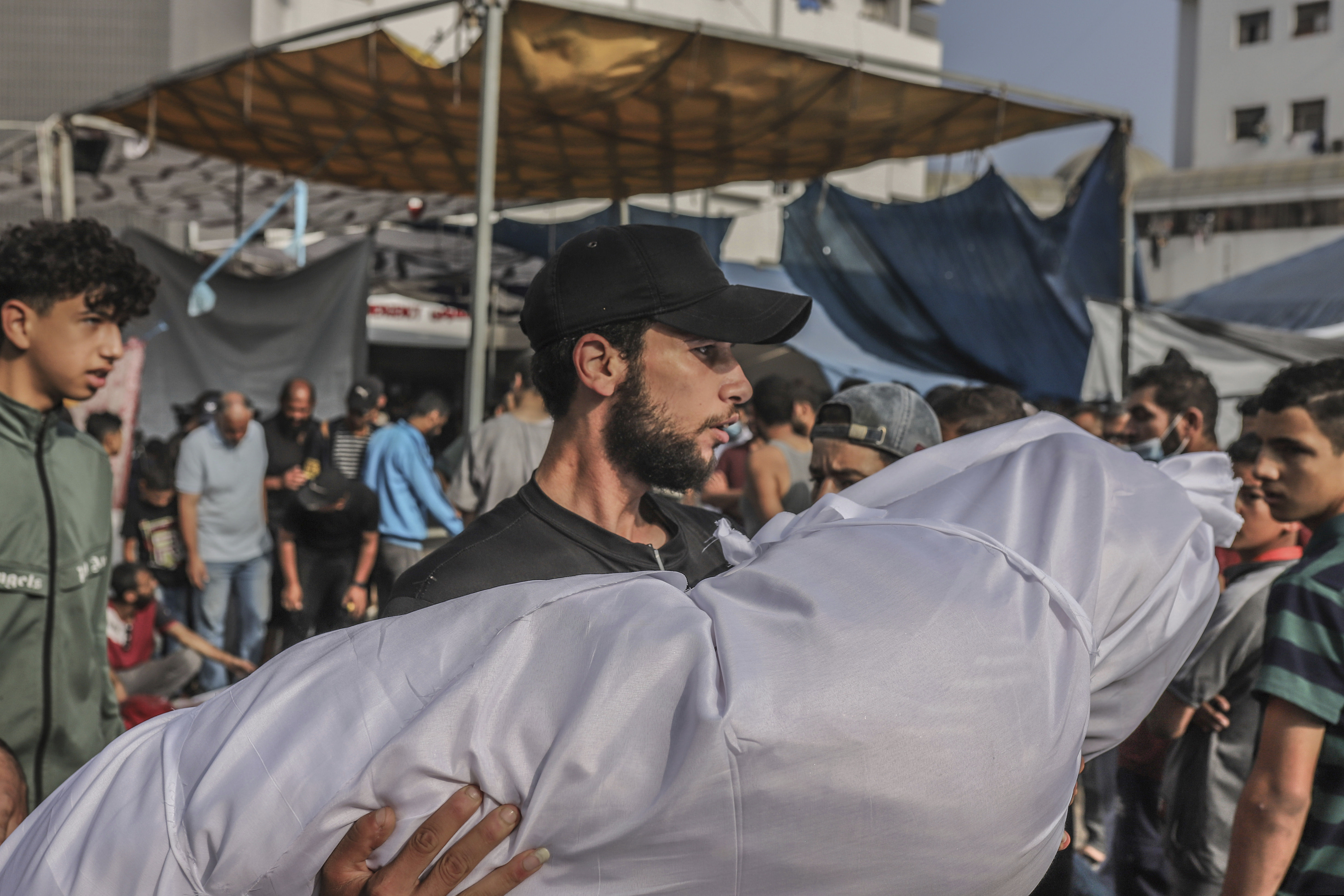 ▲▼一名巴勒斯坦人在加薩希法醫院外抬著受害者的遺體。（圖／達志影像／美聯社）