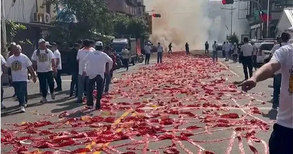 高雄左營廟會昨日舉行活動時，將鞭炮撲滿車道彷彿紅毯一般，噪音及空汙嚴重影響附近居民作息。（圖／翻攝畫面）