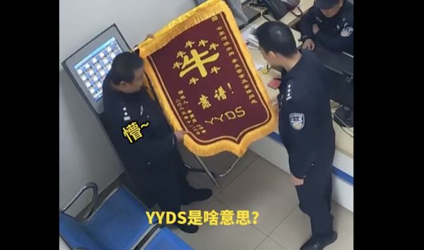 ▲資深員警收到「YYDS」錦旗，傻眼向同事求助。（圖／翻攝微博）