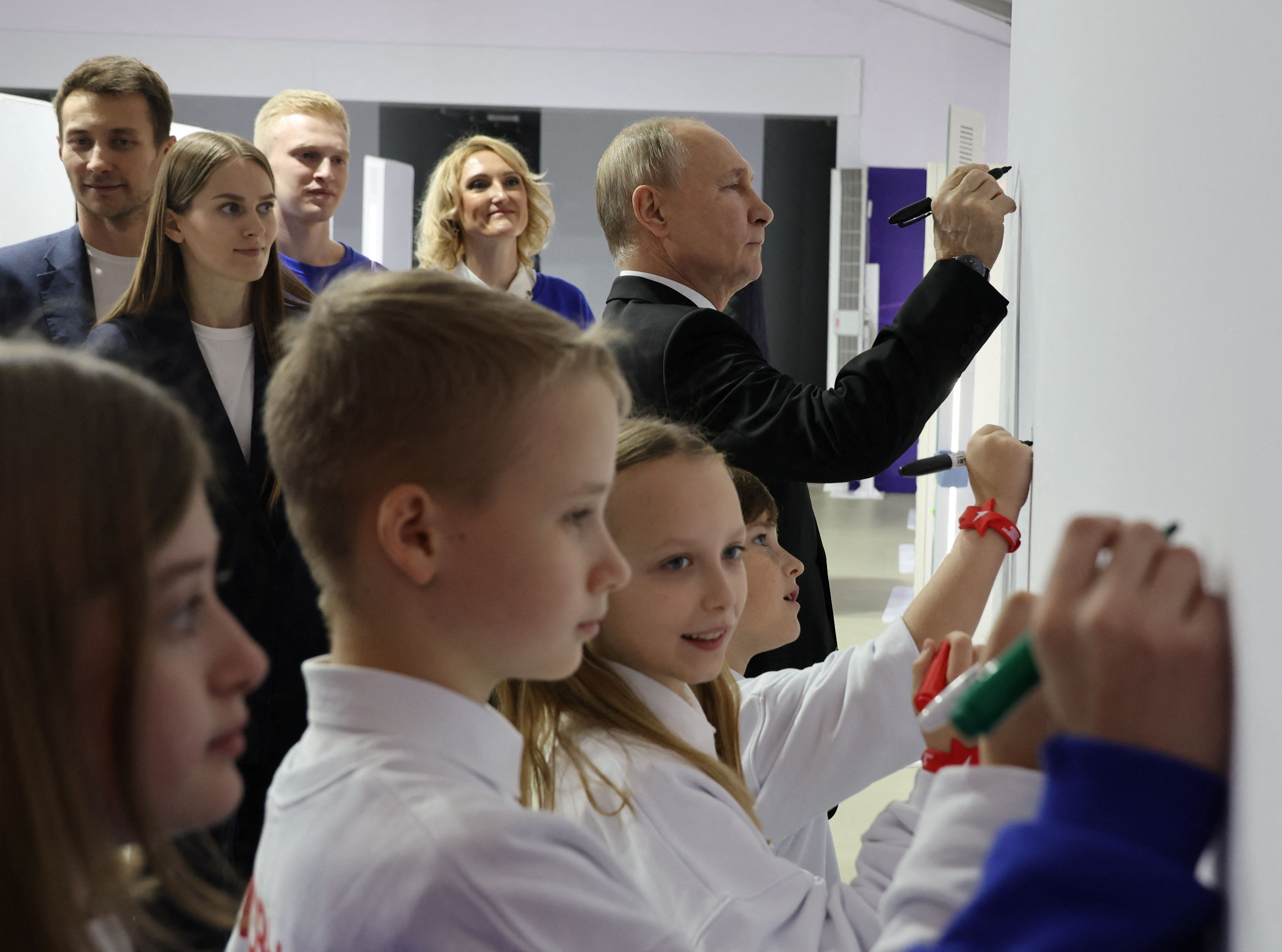 ▲▼俄羅斯總統普丁4日參觀一場展示俄羅斯成就的大型展覽，會場中展示了核試模擬控制台還有一個核按鈕，普丁與孩童們互動，一起寫下對未來的希望。（圖／路透）