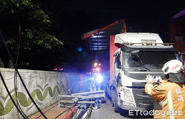 ▲桃園市八德區和平路、航安街口處今天凌晨發生大貨車過彎時，撞斷路口電桿，警消與台電人員到場處理。（圖／記者沈繼昌翻攝）