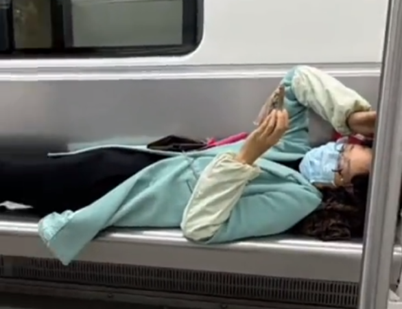 ▲女子在地鐵上躺著玩手機。（圖／翻攝自微博）