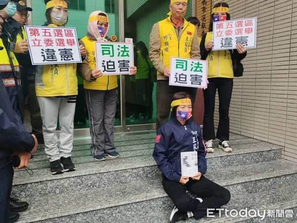 ▲台南市議員王家貞，於抽籤日上午帶著中華民國口罩，在工作人員陪同下，在台南市選委會大門口靜坐，表達對違憲惡法踐踏民主人權的深沉抗議。（圖／記者林東良翻攝，下同）