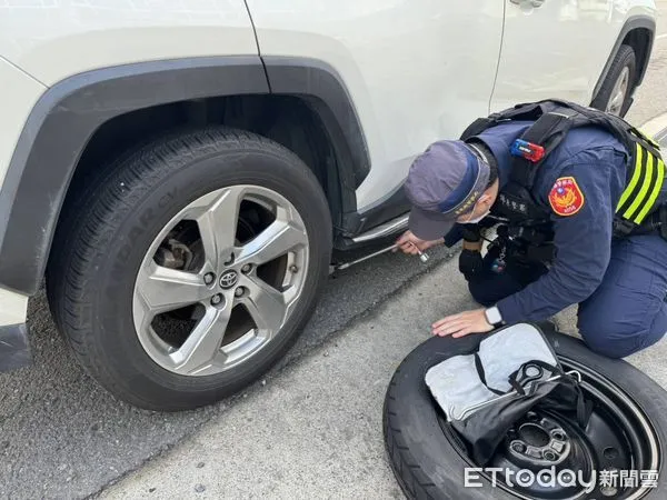 ▲女子北上趕路爆胎求助，警員協助換胎。（圖／記者楊漢聲翻攝）