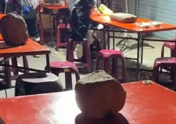 恆春夜市不少攤商為了怕桌子被強風吹倒，而擺上大石頭壓住桌子。（翻攝照片）