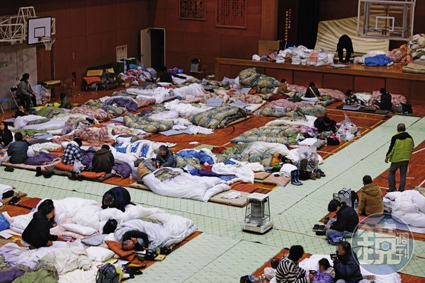 和倉小學臨時避難所收容1,200名災民，他們扶老攜幼，裹著棉被取暖。