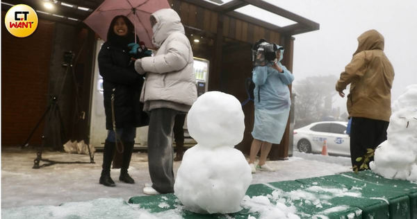 陽明山二子坪停車場下雪，吸引不少賞雪民眾追雪。（圖／方萬民攝）