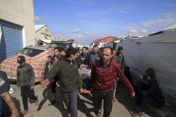 ▲▼加薩南部汗尤尼斯（Khan Younis）聯合國近東巴勒斯坦難民救濟和工程處（UNRWA）大樓，民眾抬著在空襲中喪生者的遺體。（圖／達志影像／美聯社）