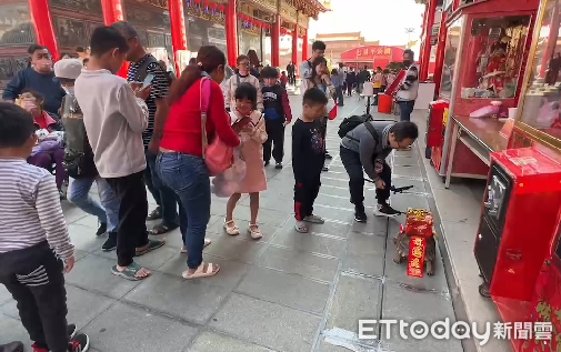 ▲來自桃園一對夫妻，帶著2隻陸龜南下行春旅遊，並在聖母廟埕「遛龜」，2隻陸龜打扮得「喜氣洋洋」，令來往遊客不禁駐足圍觀，小朋友更是好奇興奮。（圖／記者林東良翻攝，下同）