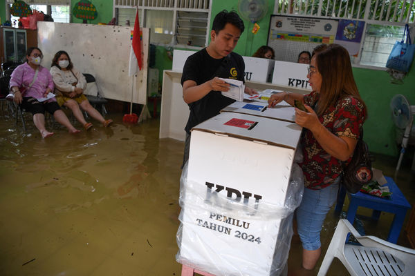 ▲▼印尼大選2月14日舉行投票，雅加達部分地區因為淹水未退，民眾雙腳泡在水中前往投票站投票。（圖／路透）