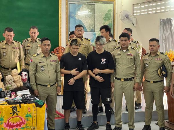 晚安小雞（左，黑衣）和友人阿鬧（右，黑衣）遭柬埔寨警方逮捕。（翻攝自《Fresh News》）