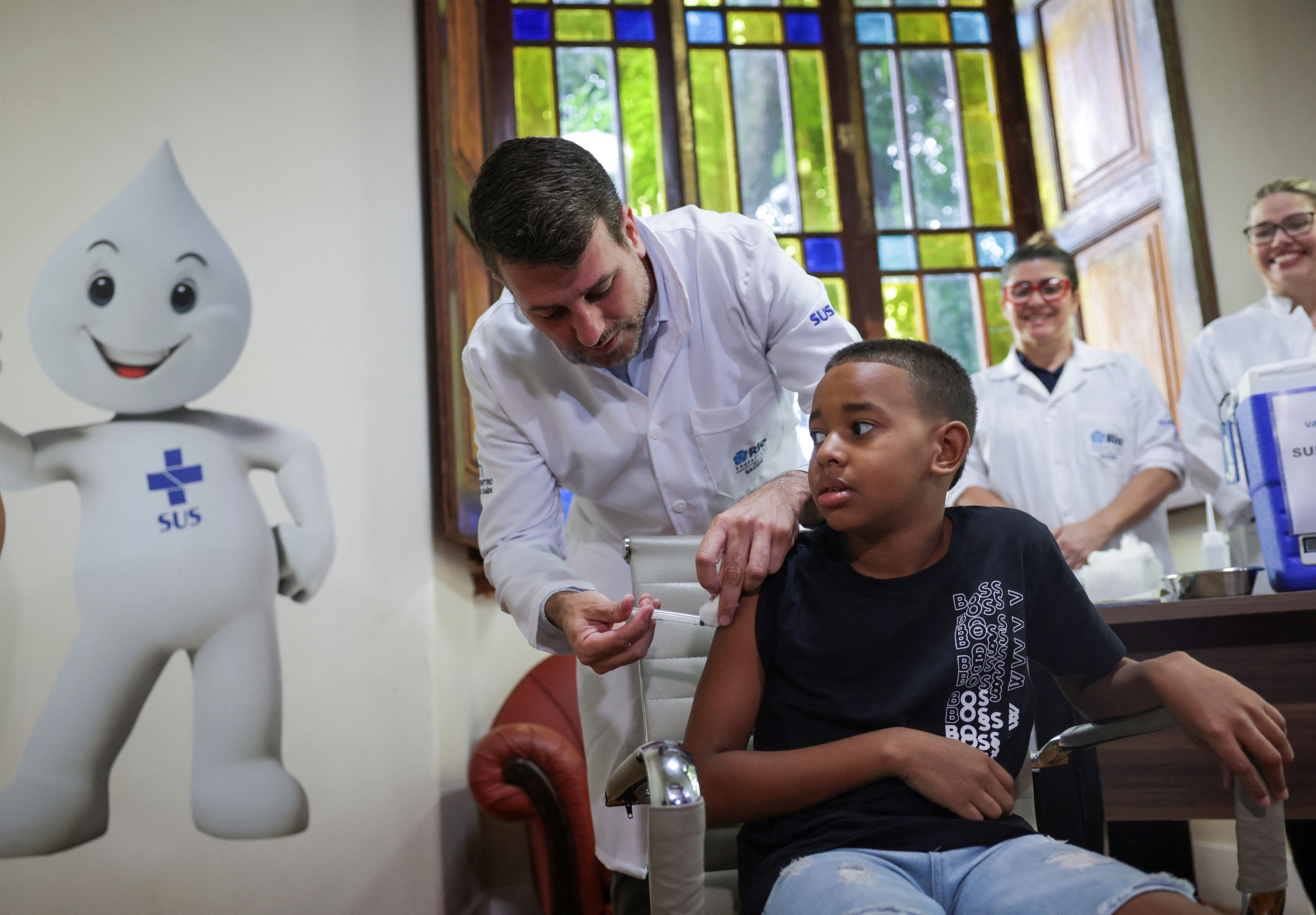 ▲▼巴西里約熱內盧爆發登革熱疫情，一名10歲男孩正在接種疫苗。（圖／路透）