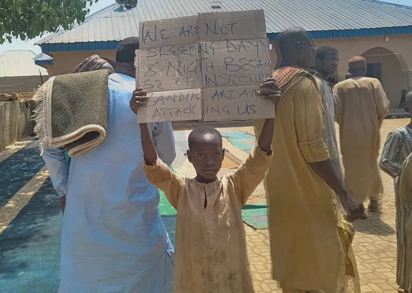 ▲▼2024年3月8日奈及利亞一名男童舉牌，抗議卡杜納州槍手綁架數百名小學生的事件。（圖／路透）